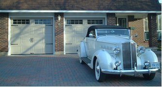 Vieille voiture devant deux portes de garage