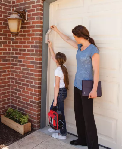 Mère et fille devant porte de garage.png