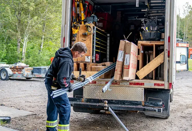 Installateurs de Portes SaguenayBalzac s'apprêtant à aller faire la réparation d'une porte de garage agricole d'une ferme de St-Nazaire
