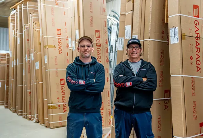 Deux installateurs homme devant des boites de portes de garage